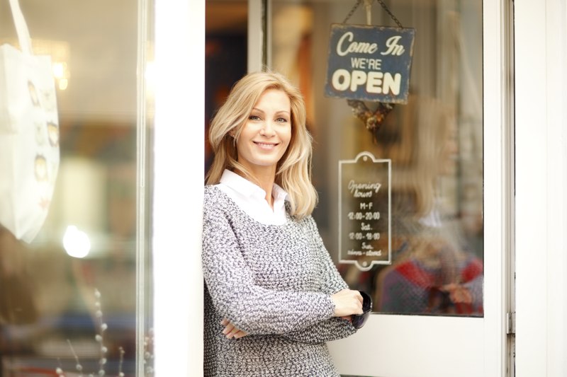 A small business owner stands in a door, wondering how much does a small business website cost?