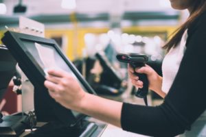 shop cashier scanning receipt at POS display