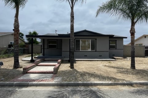 exterior of 621 Kit; small house with three large palm trees