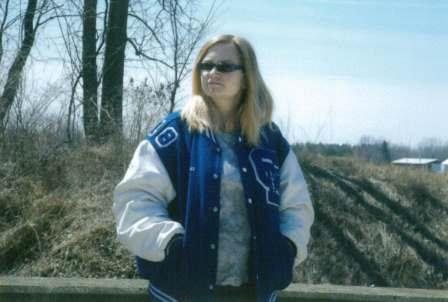 young woman in sunglasses and letter jacket