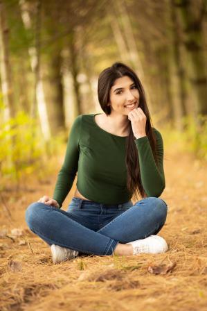 smiling young woman posing on forest ground