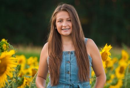 young smiling woman in a field of sunflowers