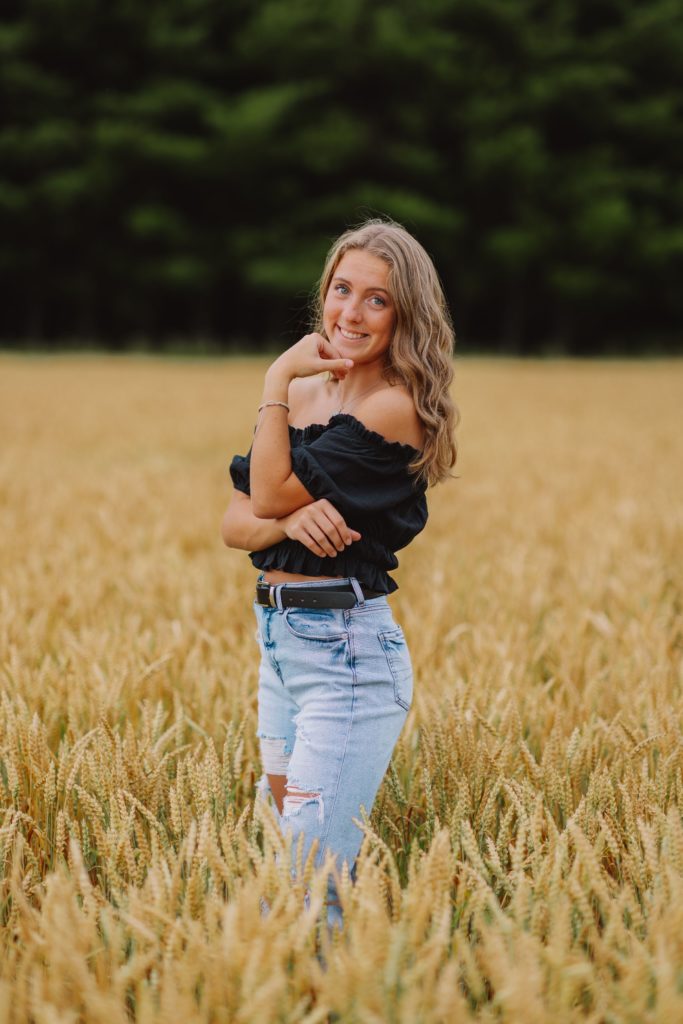 smiling young woman posing in a wheat field